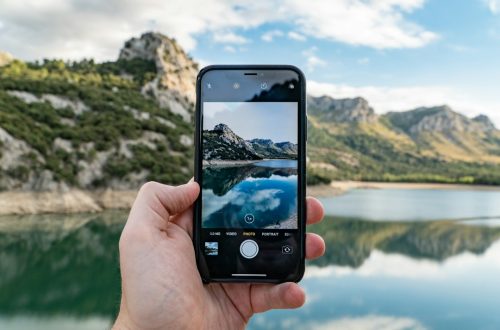 Person using a smartphone camera for AI photo editing