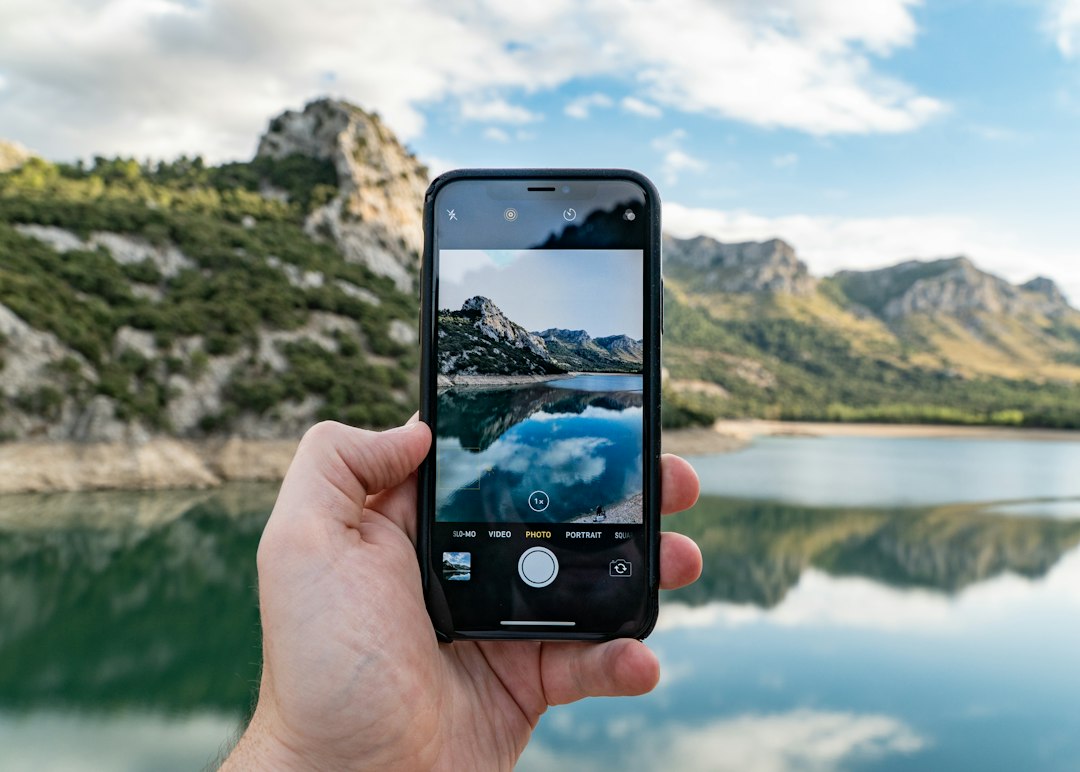 Person using a smartphone camera for AI photo editing