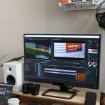 Meja kerja kreatif dengan laptop dan perangkat untuk editing video